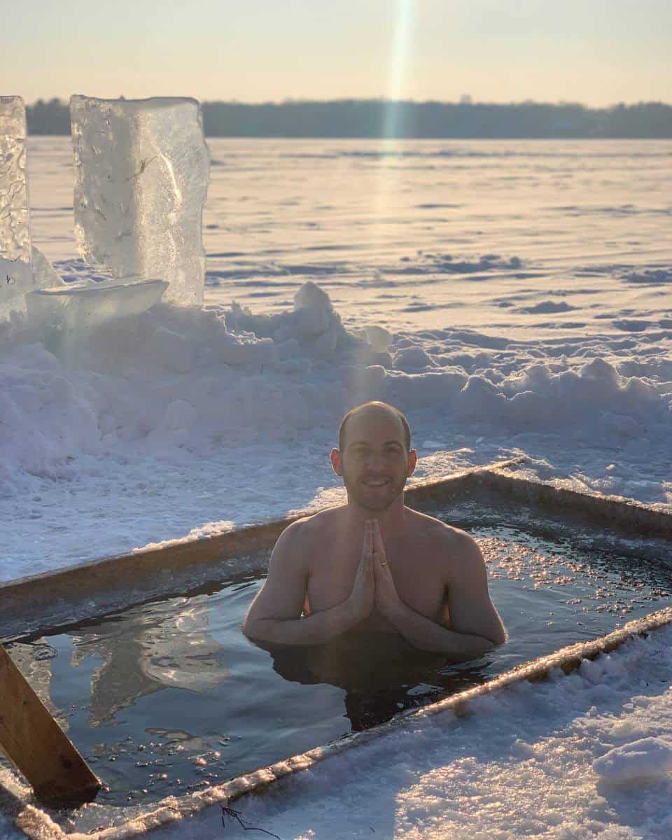 Yoni standing in water surrounded by a frozen lake, embodying stillness and reflection.