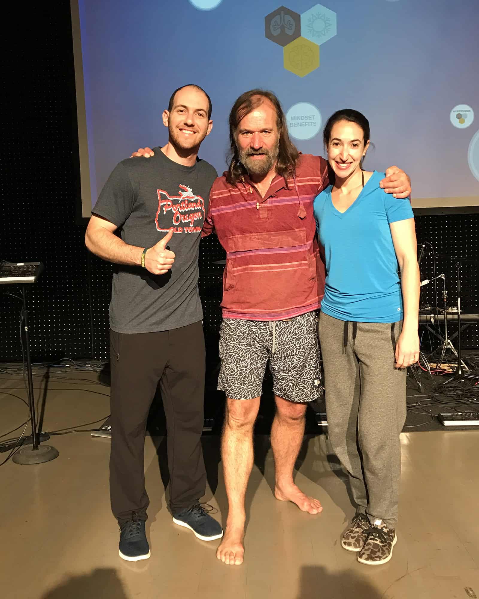 Yoni standing with Wim Hof and a woman in a breathwork workshop, reflecting resilience practice.