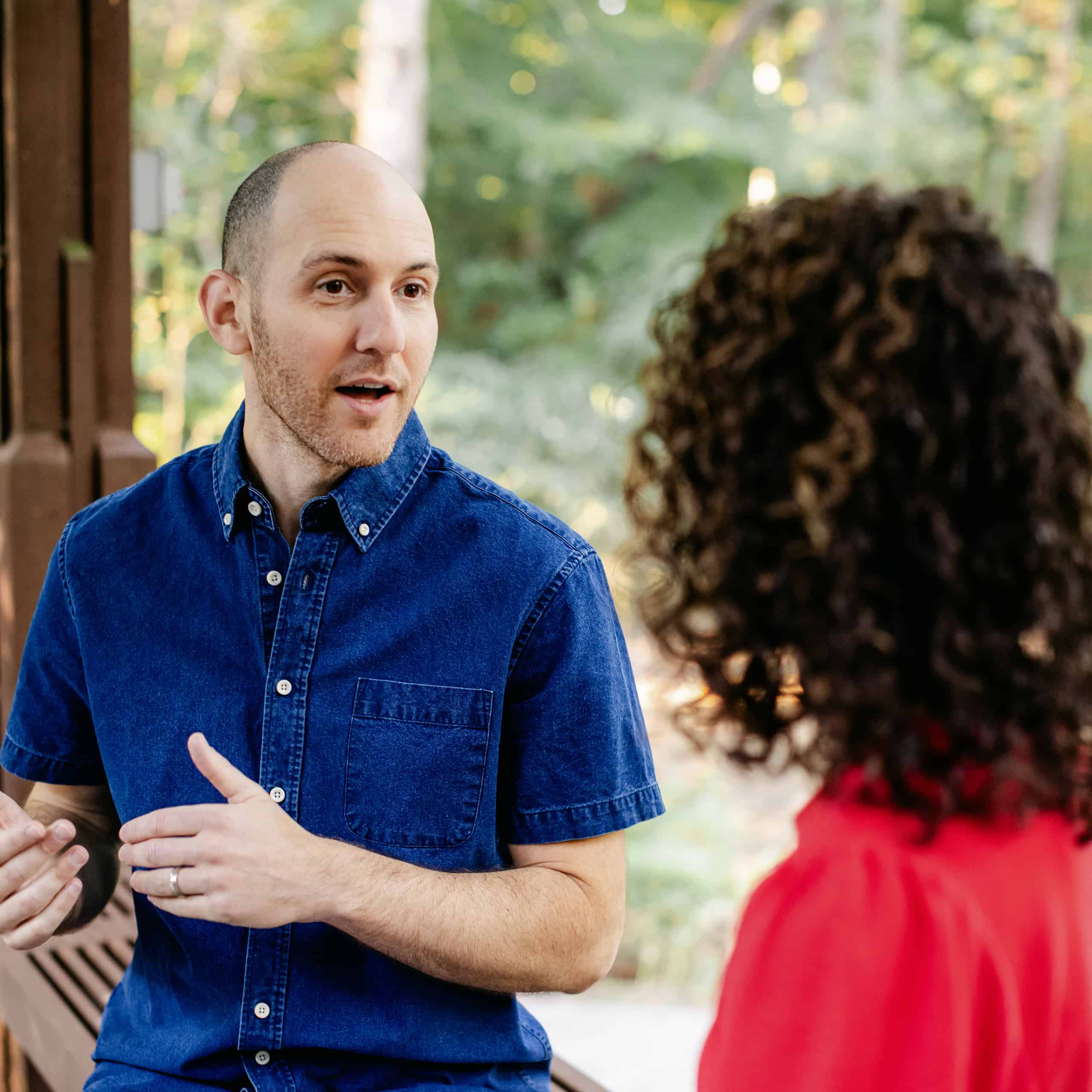 Yoni speaking with a woman outdoors, sharing presence and understanding.